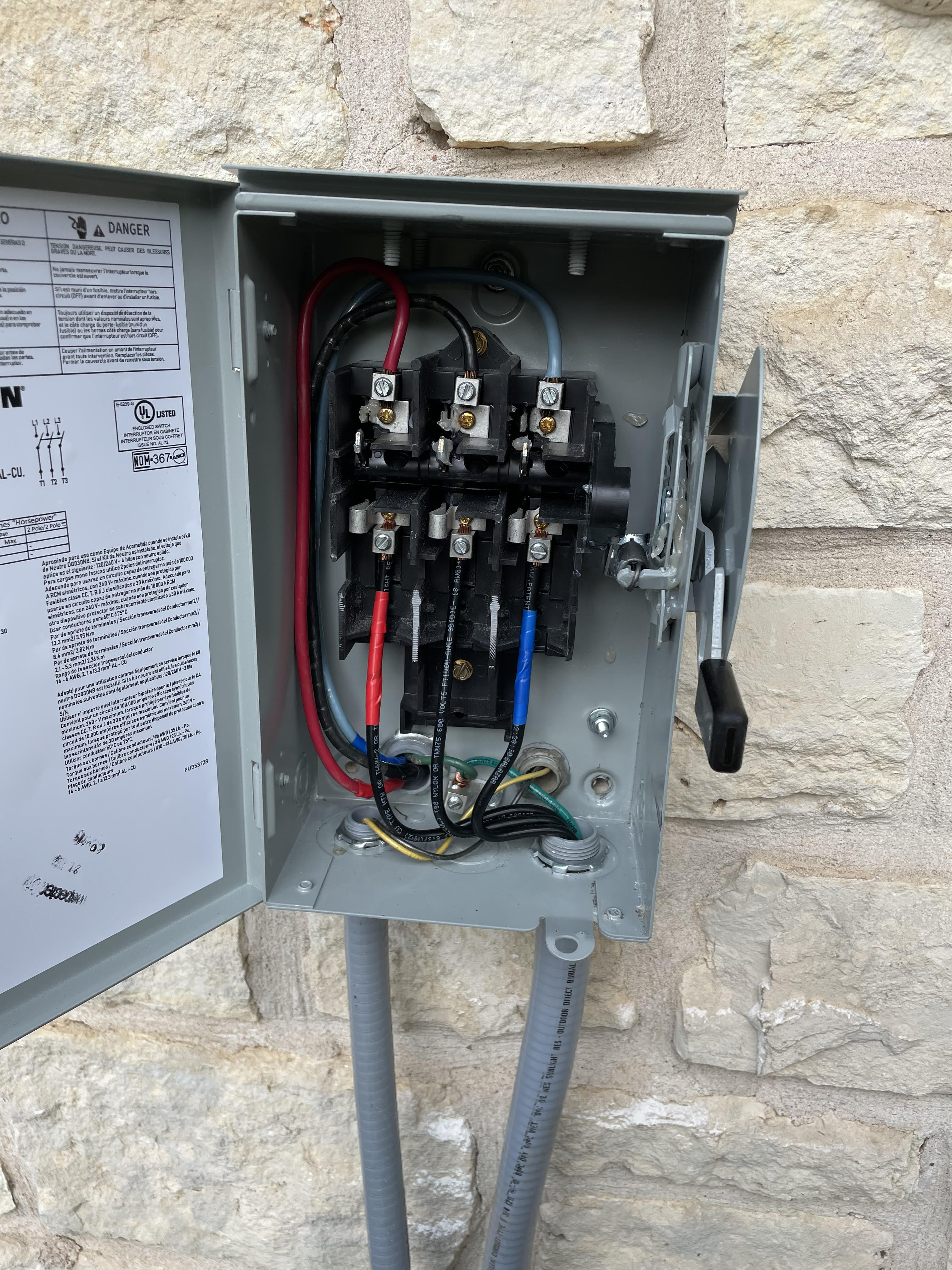 Disconnect switch installation for EV charger on stone wall in Austin TX